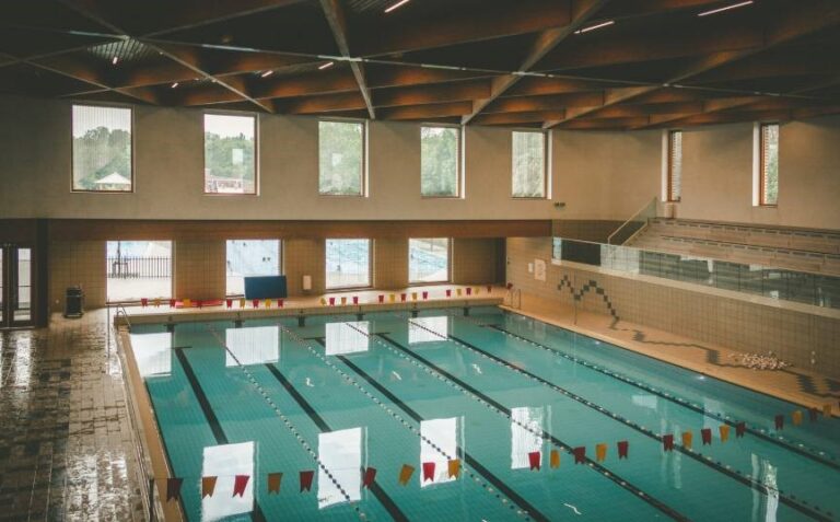 Vista interior de una piscina con señalización de seguridad