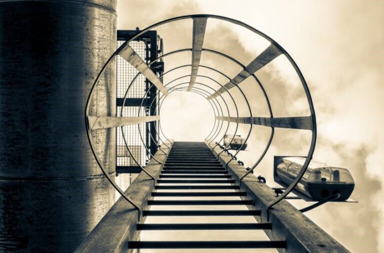 Escalera metálica vista desde abajo hacia el cielo